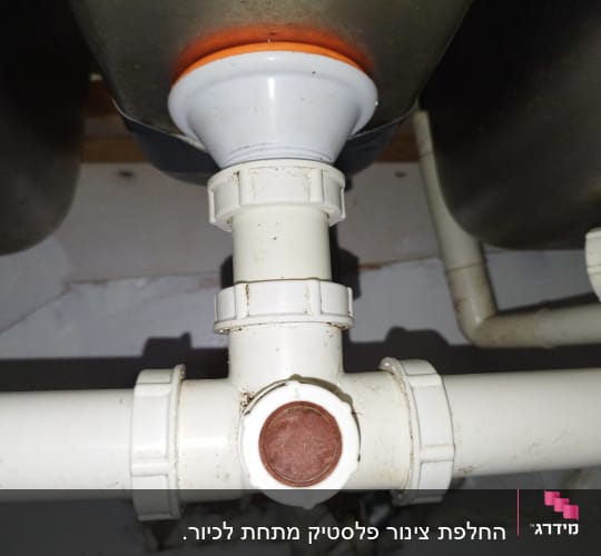 צינור פלסטיק לבן עם מחבר טי מתחת לכיור